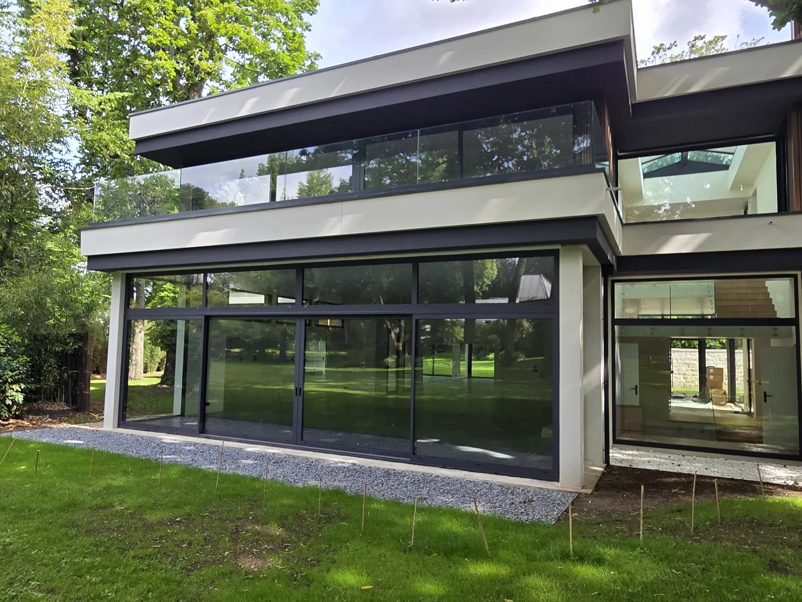 Grandes baies vitrées du rez-de-jardin sous l'étage en porte-à-faux, maison contemporaine au Vésinet