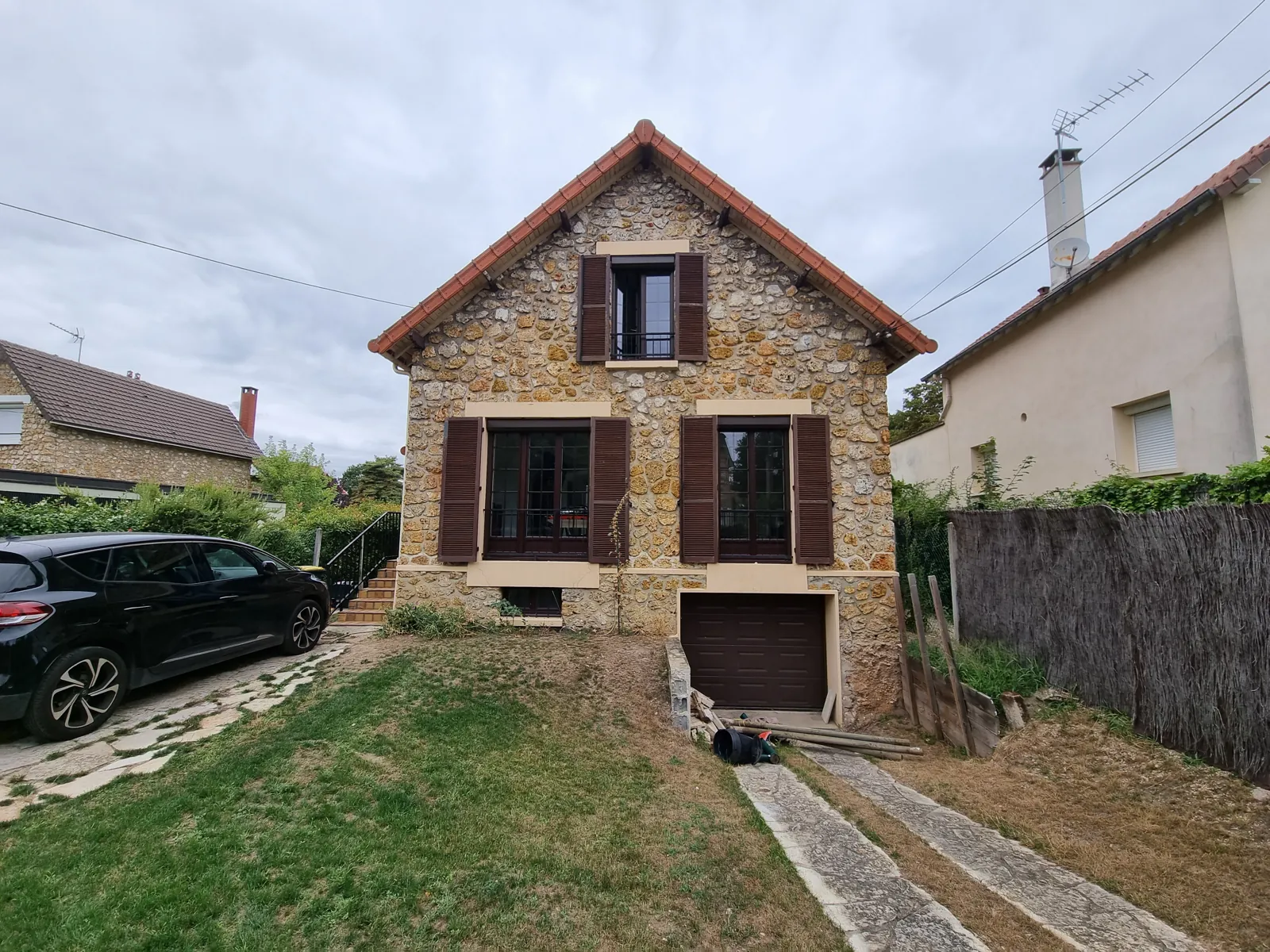 Avant travaux : maison en meulière au Vésinet, façade sur rue et garage en sous-sol
